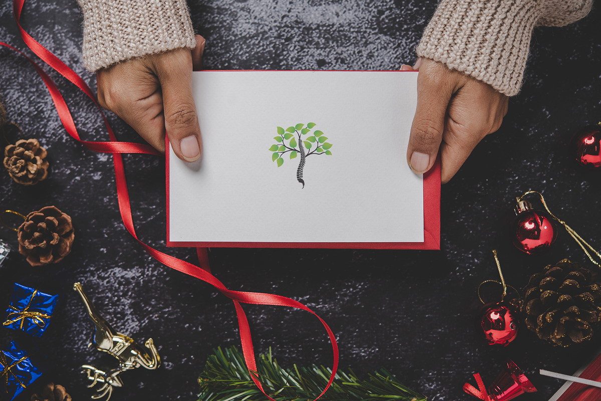 A close up picture of a woman holding a holiday gift card.